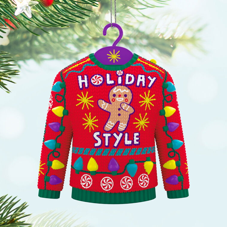 Red and green Christmas sweater ornament with gingerbread man, candy, and lights, plays "Carol of the Bells."

