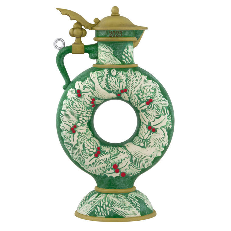 Green beer stein ornament with vintage wreath design, holly, and pinecones; features a gold lid and elegant holiday detailing.
