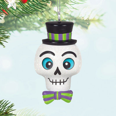 Mini Halloween skull ornament wearing sparkly top hat and bow tie with purple and green accents


