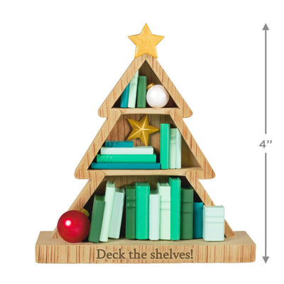 Tree-shaped wooden bookcase ornament filled with green books, red and white ornaments, and gold star accents

