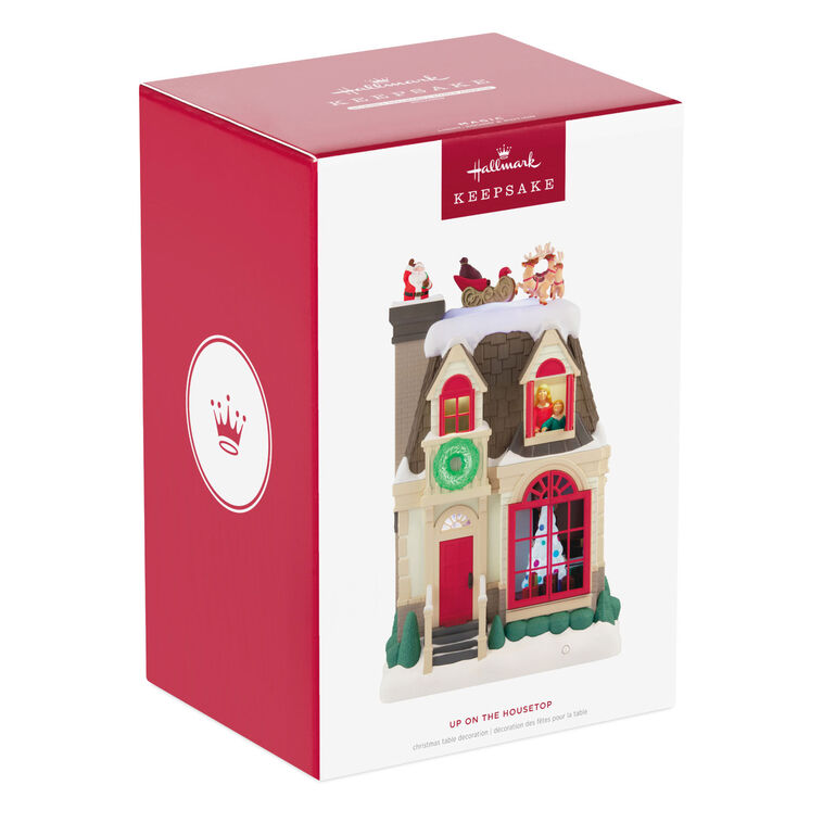 Christmas decoration showing Santa dropping down a chimney with lights, motion, and music from Up on the Housetop

