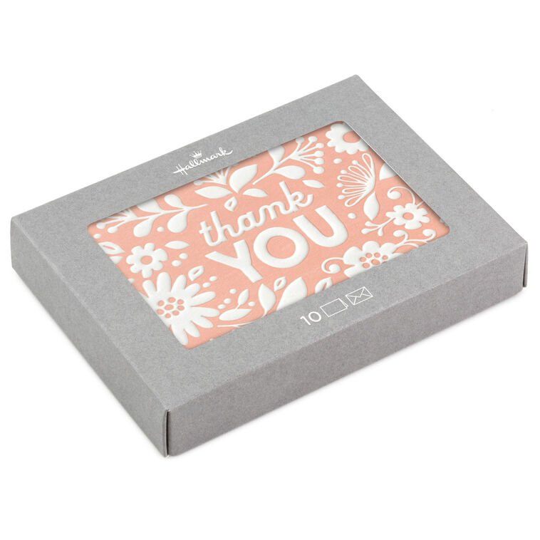 Coral thank-you cards with white embossed floral designs, shown with matching envelopes and presented in a gray gift box.
