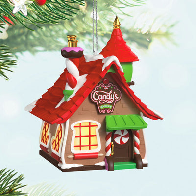 Two-piece ornament set with a festive bakery shaped like a gingerbread house and a smiling elf named Candy holding chocolate cake.