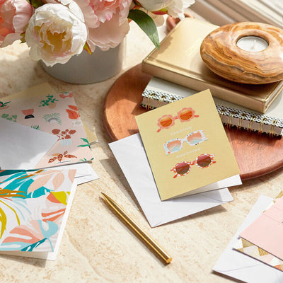 Soft pastel greeting card booklet with potted plant design on blush cover, includes 12 assorted all-occasion cards with modern illustrations and messages.
