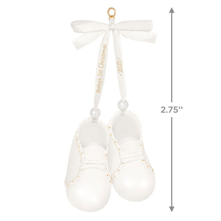 White porcelain baby booties ornament with 14K gold accents and satin ribbon bow, marked for baby’s 1st Christmas 2025.