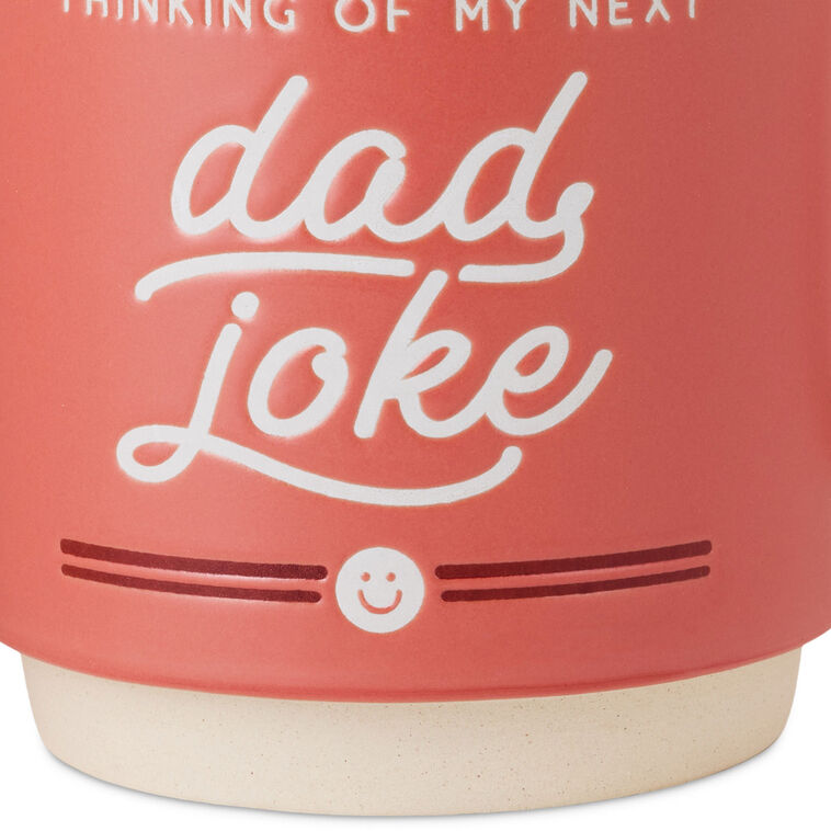 Red ceramic mug with "Thinking of my next dad joke" white lettering, smiley face design, oversized handle