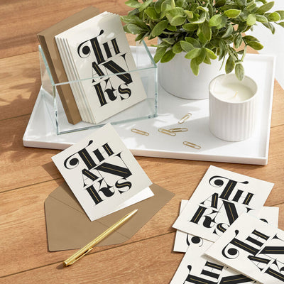 Modern black and white thank-you cards with bold uppercase lettering and gold foil details.
