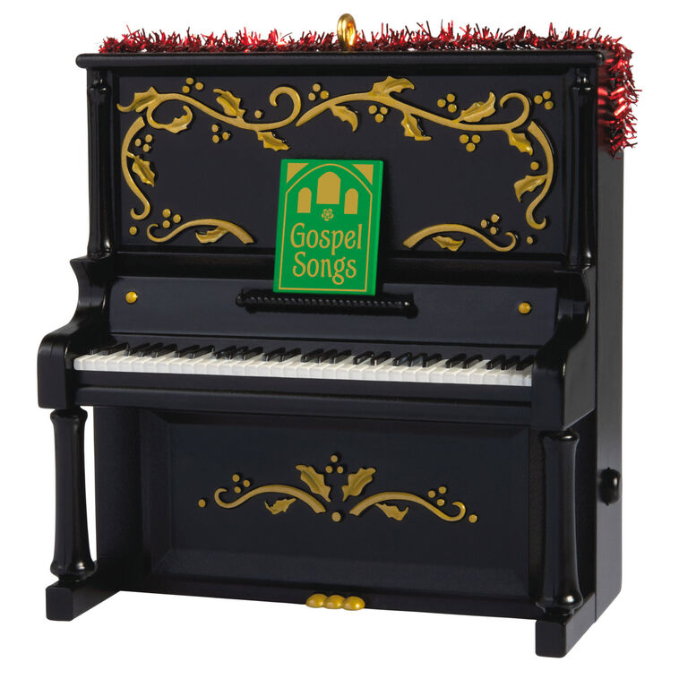 Upright Christmas piano ornament with gold holly accents, tinsel garland, and musical “I’ll Fly Away” gospel choir performa
