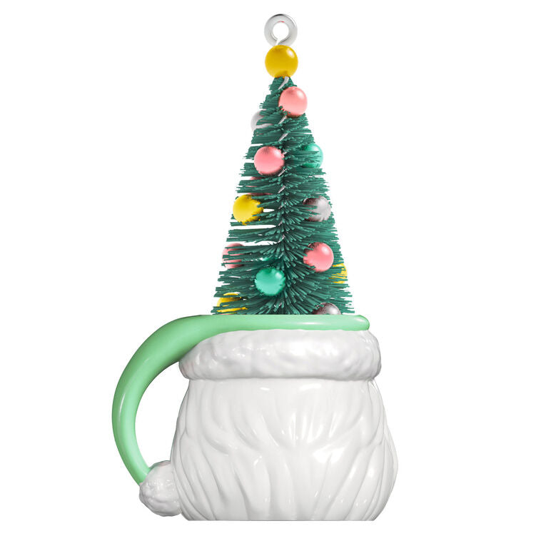 Green stocking hat mug ornament with winking Santa face and pastel ball-decorated bottlebrush tree inside

