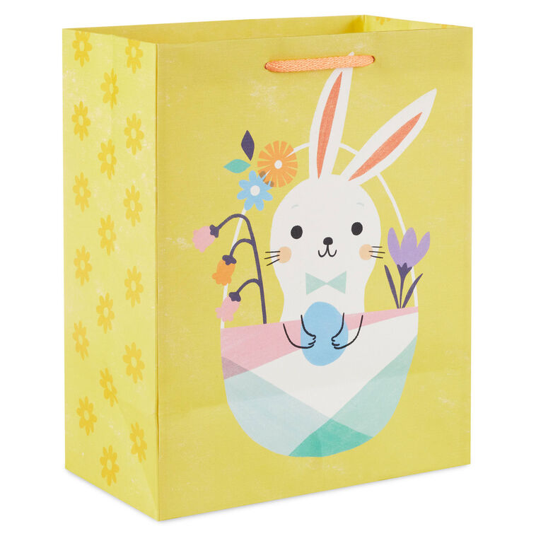 Hallmark Easter gift bag with white bunny in pastel basket on yellow background and floral accents.