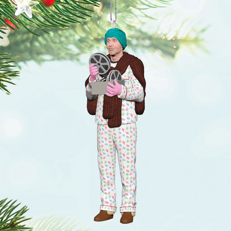 Hallmark Keepsake ornament of Clark Griswold in pajamas, fur stole, gloves, and turban holding a projector from National Lampoon&