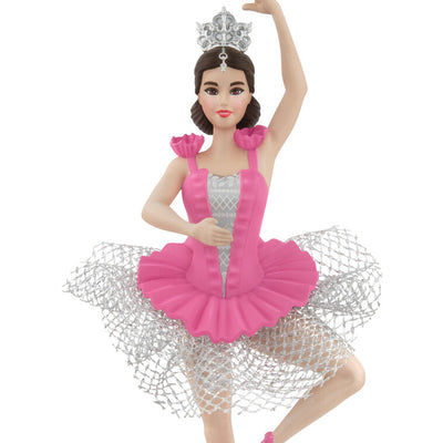 Barbie ballerina Christmas ornament wearing a pink tutu, pointe shoes, and silver tiara, posed en pointe with arm raised in a graceful ballet position.