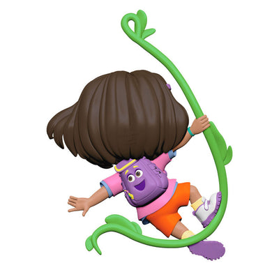 Dora the Explorer ornament swinging on jungle vine, pink shirt, orange shorts, purple backpack, Hallmark Keepsake holiday decor.