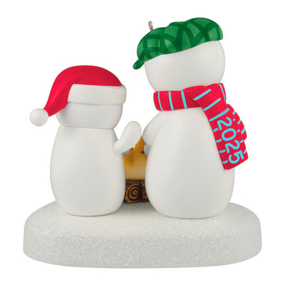 Two snowmen in red and green hats roasting marshmallows over a fire, sparkly base, musical Christmas ornament, battery opera

