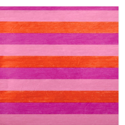 Hallmark tissue paper in horizontal magenta, orange, and pink stripes, styled in flat lay and fluffed in a gift bag for festive presentation