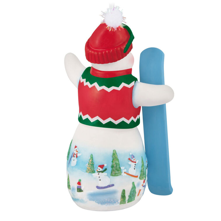 Hallmark Keepsake Ollie U. Halfpipe porcelain snowman ornament in red sweater vest, goggles, stocking hat, holding snowboard, snowy mountain scene