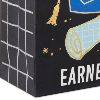 Medium black graduation gift bag with "Learned It. Earned It." and blue mortarboard and diploma, Hallmark, gold foil accents, 9.6 inch size
