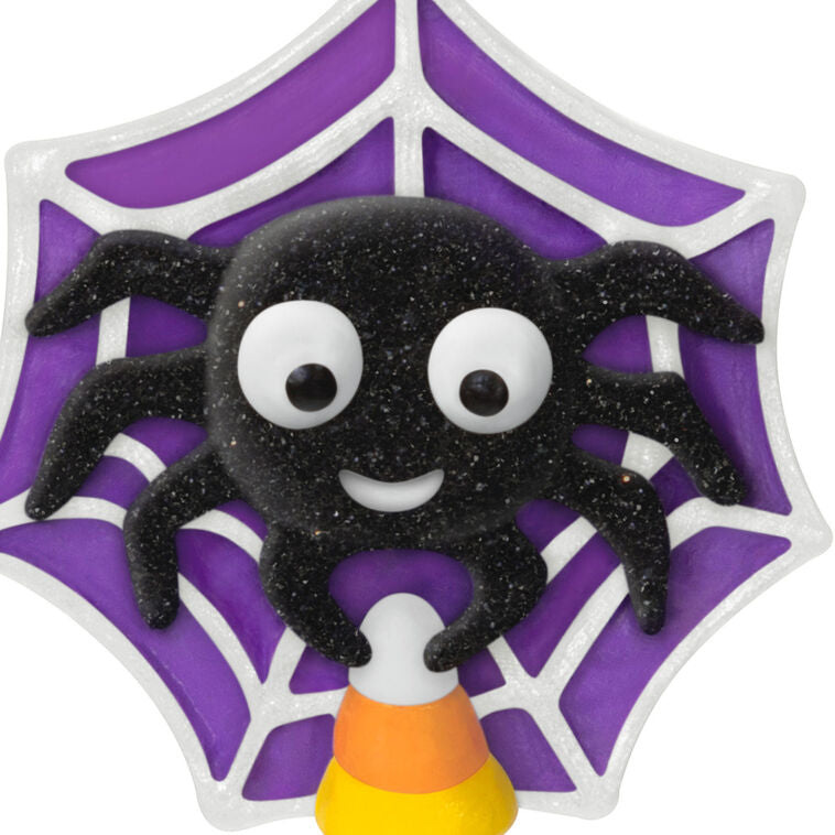 Mini Halloween spider ornament holding candy corn in sparkly web, perfect for tabletop tree display