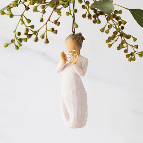 Willow Tree 2025 Ornament figurine in cream dress holding a golden wire heart with 2025 inside, hanging by a brown cord.
