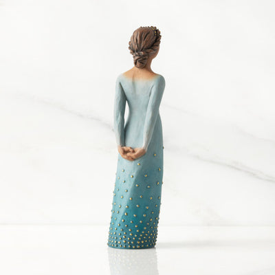 Willow Tree Radiance figurine with darker skin in a deep blue ombré dress dotted with gold leaf.