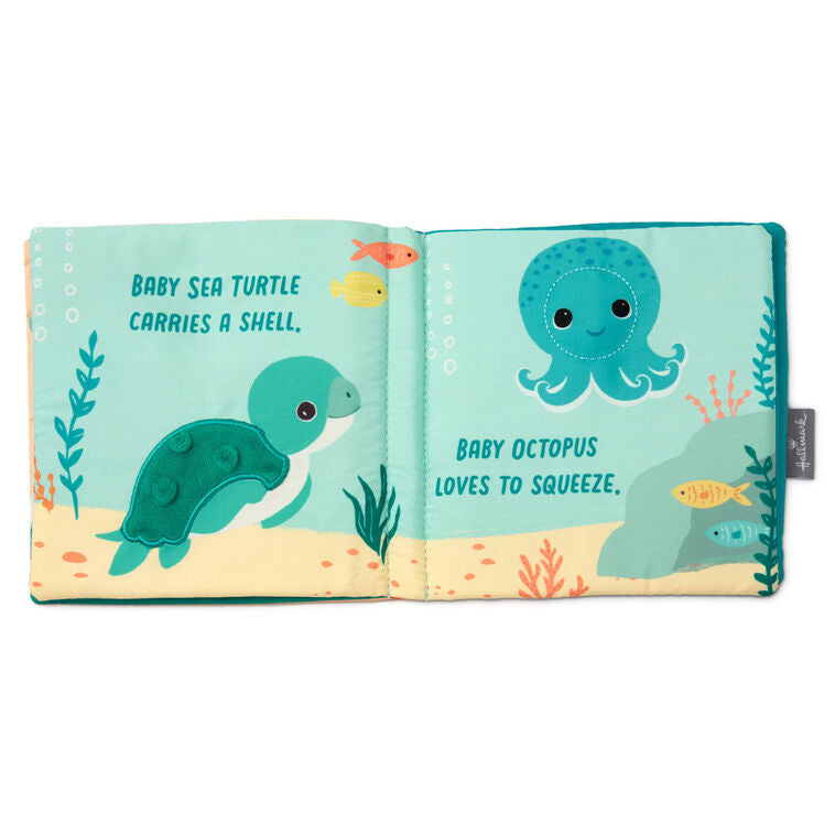 Ocean-themed baby fabric book with sea creature illustrations and tactile features like crinkle paper, squeaker