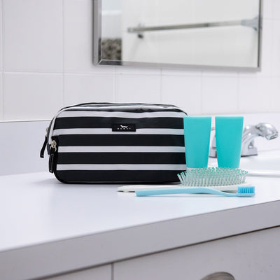 Late Bloomer 3-Zip toiletry bag with three compartments for organizing toiletries, makeup, or school supplies; stands upright.