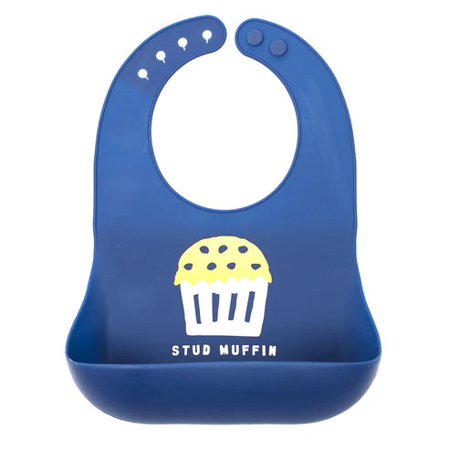 Navy blue silicone baby bib with “Stud Muffin” phrase, featuring a large food-catching pocket and adjustable neck closure.

