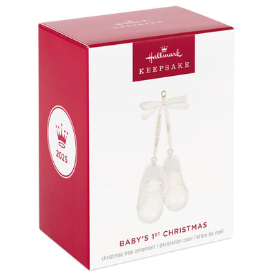 White porcelain baby booties ornament with 14K gold accents and satin ribbon bow, marked for baby’s 1st Christmas 2025.