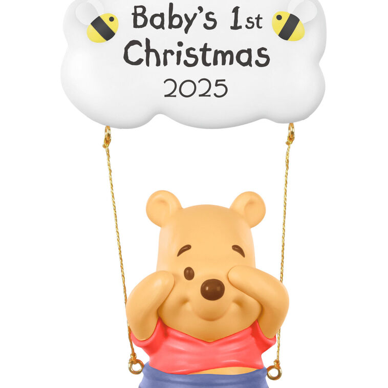 Winnie the Pooh Christmas ornament swinging under a "Baby’s 1st Christmas 2025" cloud with hunny pot and bee accents