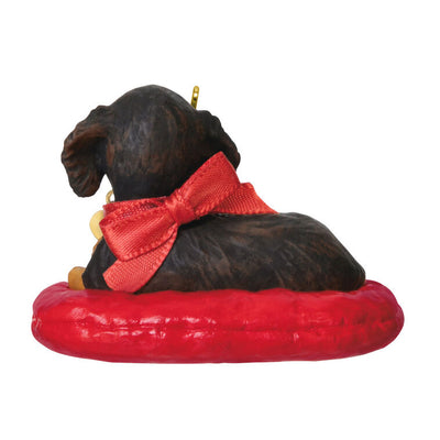 Hallmark Keepsake ornament of long-haired dark and light brown dachshund on red dog bed, red bow with 2025 heart charm