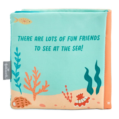 Ocean-themed baby fabric book with sea creature illustrations and tactile features like crinkle paper, squeaker