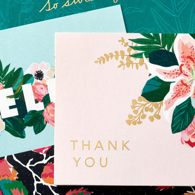 Boxed floral note card set featuring four unique designs with gold foil accents, includes 40 cards and envelopes.
