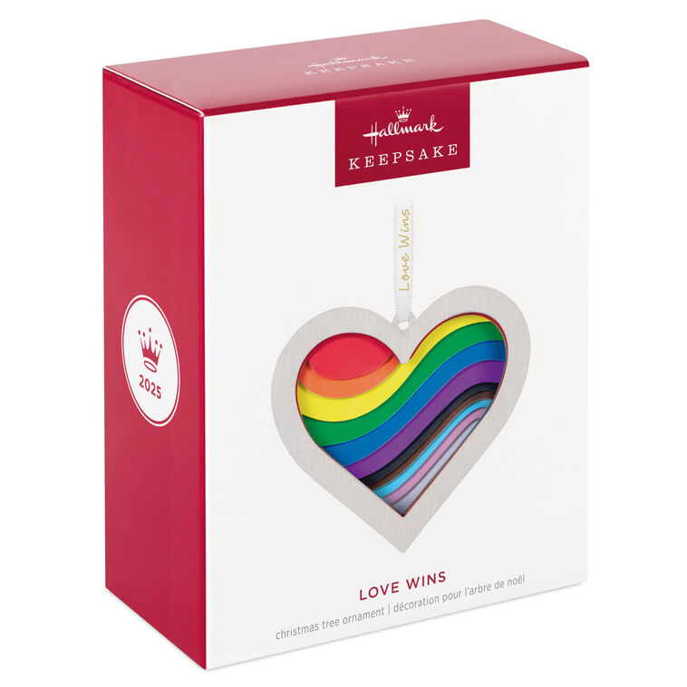 Heart-shaped rainbow papercraft ornament in a whitewashed wood frame with “Love Wins” ribbon for LGBTQIA holiday celebration.
