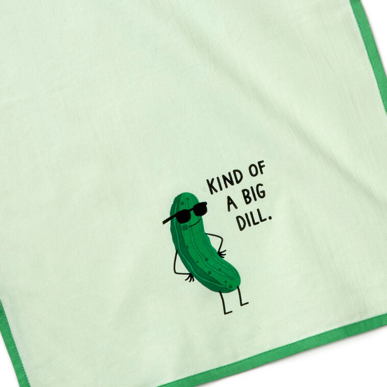 White tea towel with green border, featuring a dill pickle in sunglasses and the phrase: “Kind of a big dill.”