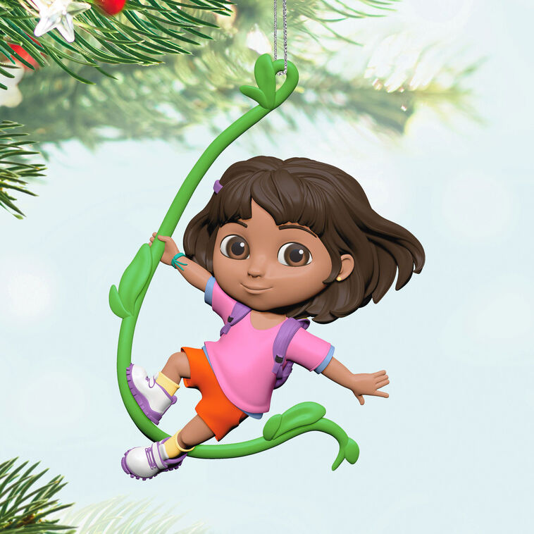 Dora the Explorer ornament swinging on jungle vine, pink shirt, orange shorts, purple backpack, Hallmark Keepsake holiday decor.