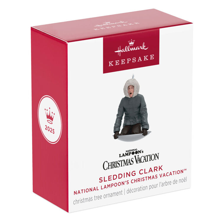 Hallmark Keepsake Mini National Lampoon’s Christmas Vacation Sledding Clark ornament—Clark in parka on saucer sled, startled expression, snowy hill