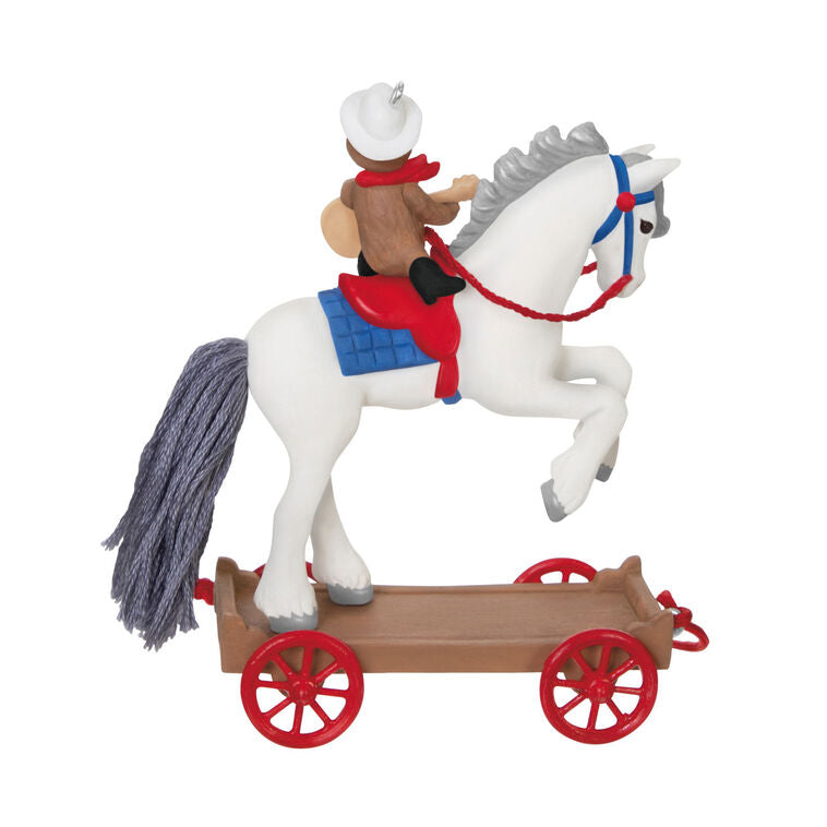 2025 ornament of a teddy bear cowboy on a white pony with red wheels, wearing a hat and scarf, strumming a guitar on a rolling wood-tone base.