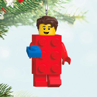 LEGO minifigure ornament with red brick body and blue hand-held piece, smiling boy with brown hair.