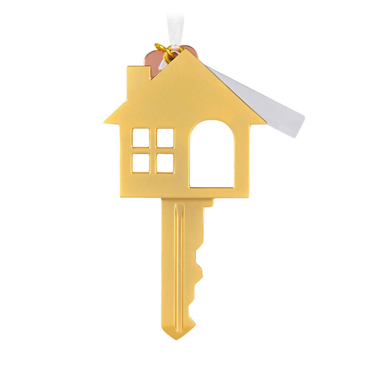 Gold metal key ornament shaped like a house with a pink heart and “New Home” banner charm, for new homeowners.
