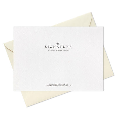 Blush pink thank-you cards with gold foil “Merci” script lettering and matching foil-lined envelopes in a white display box.
