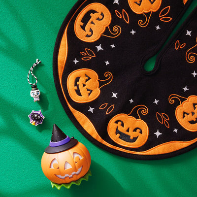 Mini Halloween skull ornament wearing sparkly top hat and bow tie with purple and green accents

