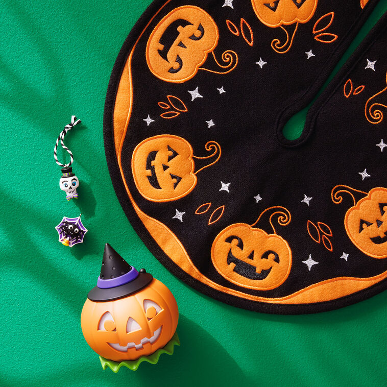 Mini Halloween skull ornament wearing sparkly top hat and bow tie with purple and green accents

