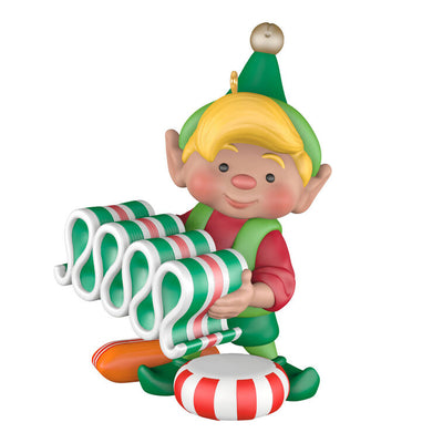 Hallmark Keepsake North Pole Tree Trimmers ornament—Santa’s elf holding old-fashioned ribbon candy, surrounded by hard candies, green hat and red suit
