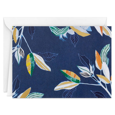 Elegant blank note cards with gold-accented tropical leaves on navy background, boxed set of 10 with white envelopes.
