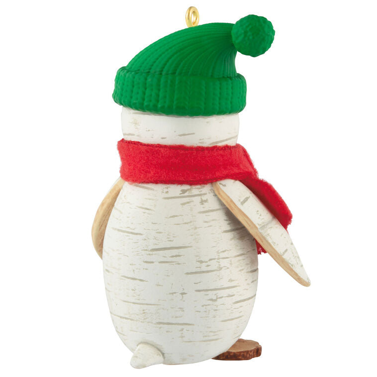Penguin Christmas ornament styled like birch wood, wearing red scarf and green stocking hat