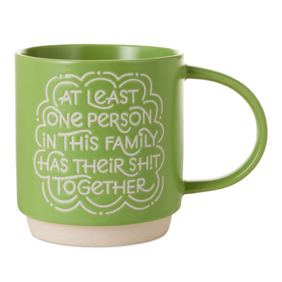 Bright green ceramic mug with white lettering that reads “At least one person in this family has their sh!t together
