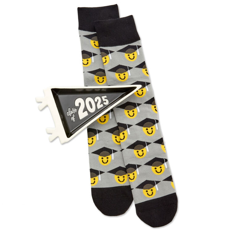 Class of 2025 black-and-white trinket tray with matching socks featuring smiley faces in graduation caps.


