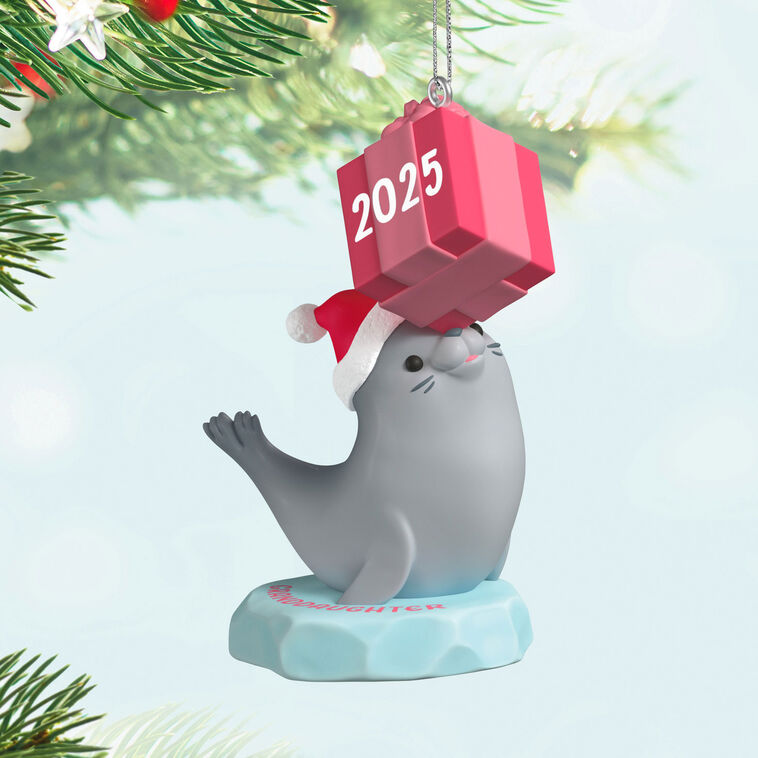 2025 Christmas ornament with gray seal in Santa hat on iceberg, balancing pink present on nose, festive design

