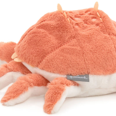 Orange and white plush crab stuffed animal made of soft fabric with floppy claws, perfect for cuddling or nautical nursery