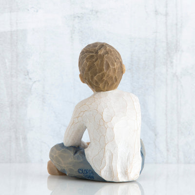 Willow Tree Imaginative Child figurine seated cross-legged with arms folded in lap.
